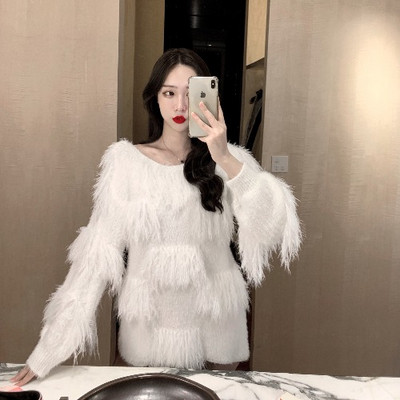 Ένα μοντέρνο φαρδύ πουλόβερ με κρόσσια σε λευκό και ροζ χρώμα