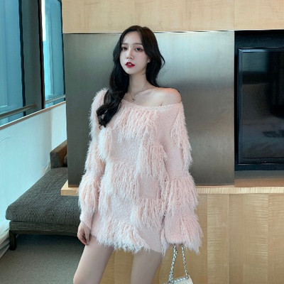 Ένα μοντέρνο φαρδύ πουλόβερ με κρόσσια σε λευκό και ροζ χρώμα