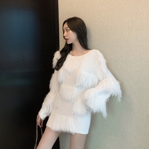 Ένα μοντέρνο φαρδύ πουλόβερ με κρόσσια σε λευκό και ροζ χρώμα