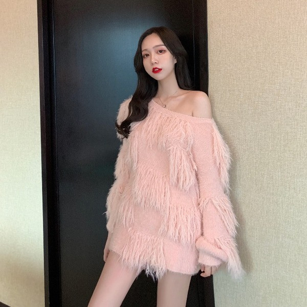 Ένα μοντέρνο φαρδύ πουλόβερ με κρόσσια σε λευκό και ροζ χρώμα