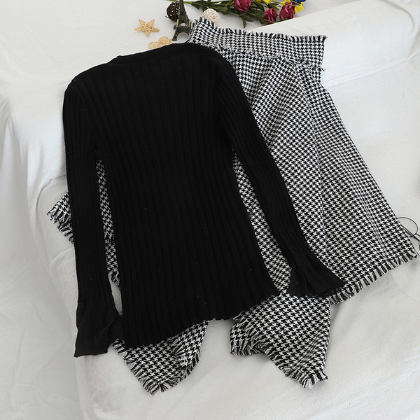 Női szett, mely tartalmaz egy fekete pulóvert és egy kockás szoknyát magas derékkal