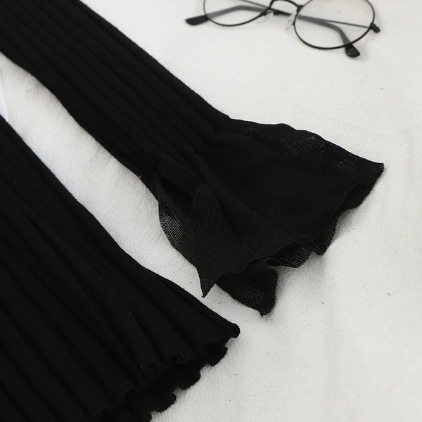 Női szett, mely tartalmaz egy fekete pulóvert és egy kockás szoknyát magas derékkal