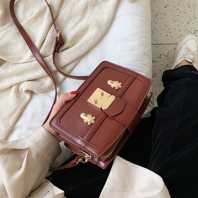 Modern női táska fém elemmel, hosszú fogantyúval