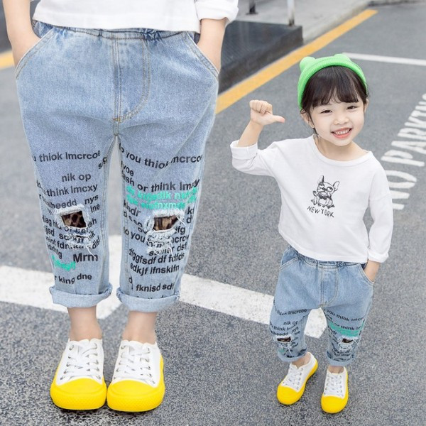 Modern, kék színű gyerekfarmer, feliratokkal és zsebekkel lányoknak