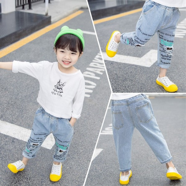 Modern, kék színű gyerekfarmer, feliratokkal és zsebekkel lányoknak