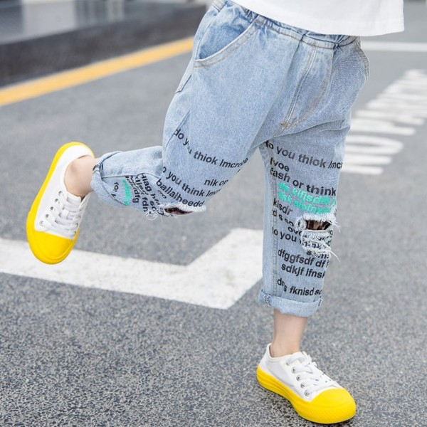 Modern, kék színű gyerekfarmer, feliratokkal és zsebekkel lányoknak