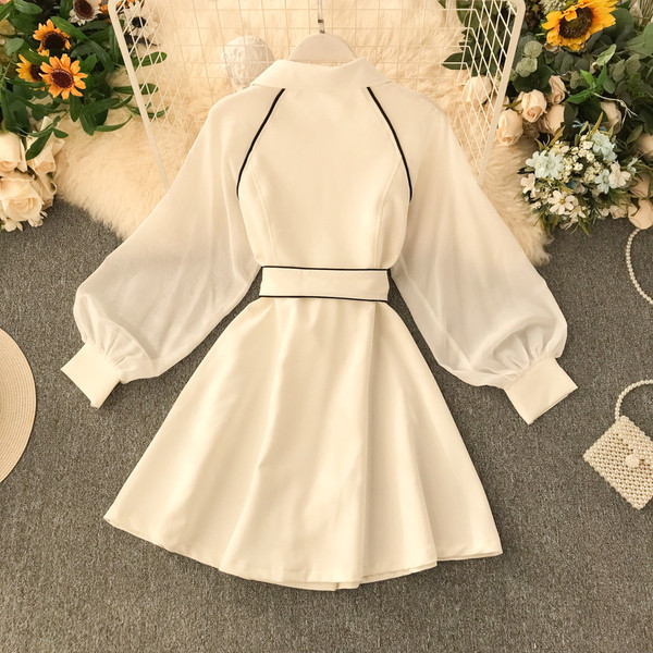 Modern női ruha fekete-fehér övvel és gombokkal