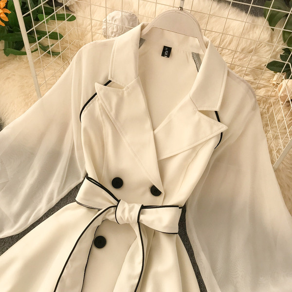 Modern női ruha fekete-fehér övvel és gombokkal