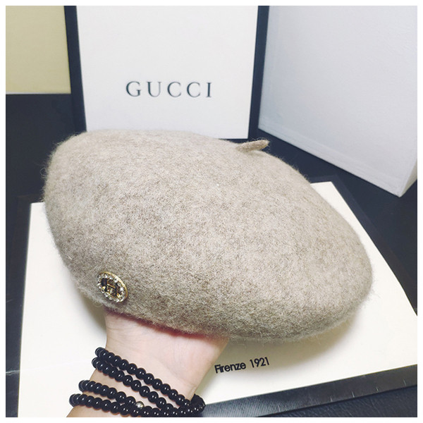 Stílusos női sapka fém díszítéssel fekete és bézs színben