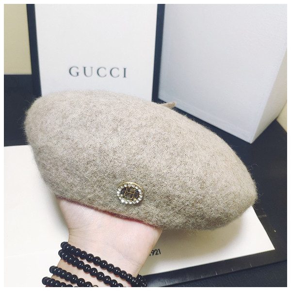 Stílusos női sapka fém díszítéssel fekete és bézs színben