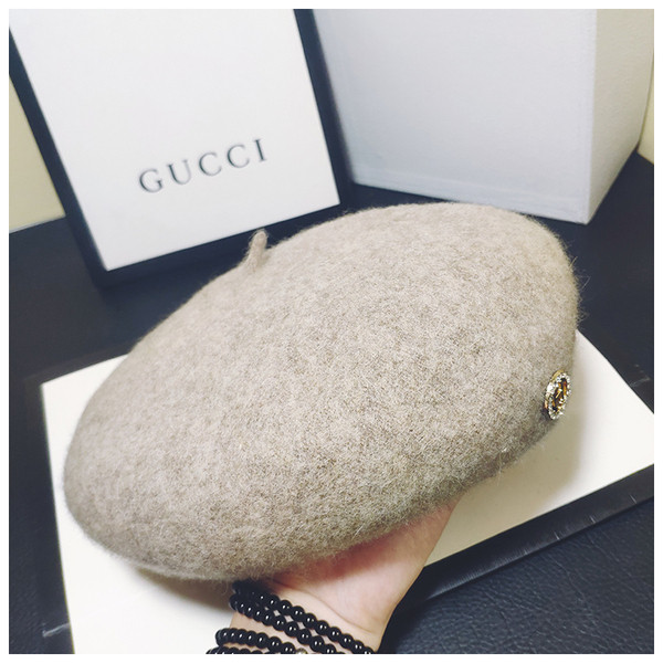 Stílusos női sapka fém díszítéssel fekete és bézs színben