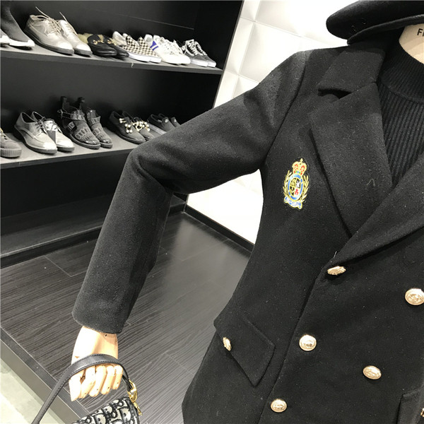 Stílusos női kabát dupla rögzítéssel és fekete hímzéssel