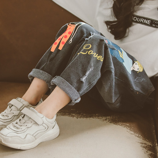 Blugi moderni pentru copii cu motive rupte si aplicatii in albastru si negru pentru fete