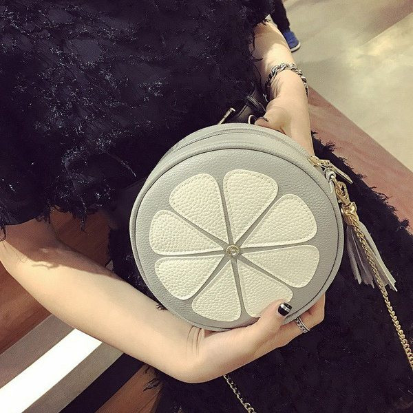 Hétköznapi női táska cipzárral és fém lánccal, kerek formában