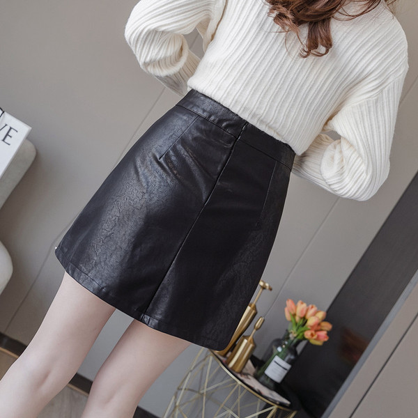 Fekete rövid női bőrszoknya hasítékkal és szegecsekkel