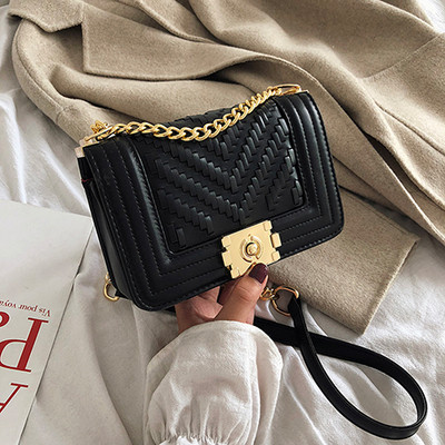 Stílusos kézitáska fém elemekkel és hosszú fogantyúval