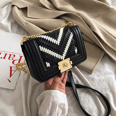 Stílusos kézitáska fém elemekkel és hosszú fogantyúval