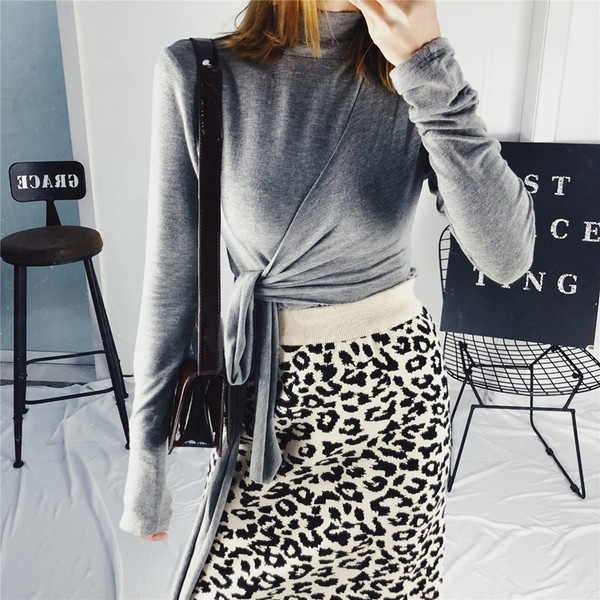 Σύντομο γυναικείο πουλόβερ με υψηλό κολάρο και κορδόνι στη μέση