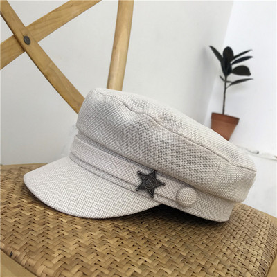 Modern női sapka fém elemmel fehér és fekete színben