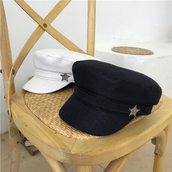 Modern női sapka fém elemmel fehér és fekete színben