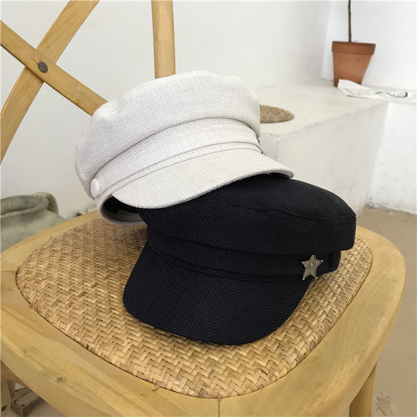 Modern női sapka fém elemmel fehér és fekete színben