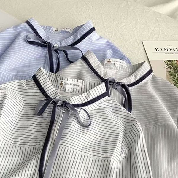 Bluză de damă modernă în dungi cu guler jos și cravate în alb, albastru și gri