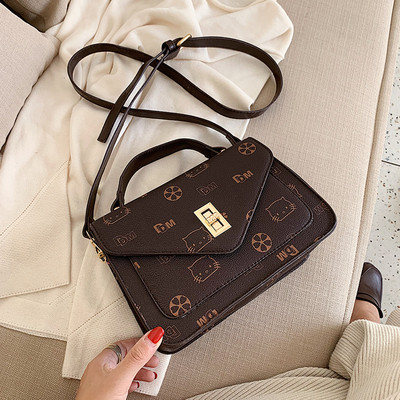 Μοντέρνα γυναικεία τσάντα με μεταλλικό κούμπομα και μεγάλη λαβή