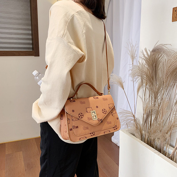 Μοντέρνα γυναικεία τσάντα με μεταλλικό κούμπομα και μεγάλη λαβή