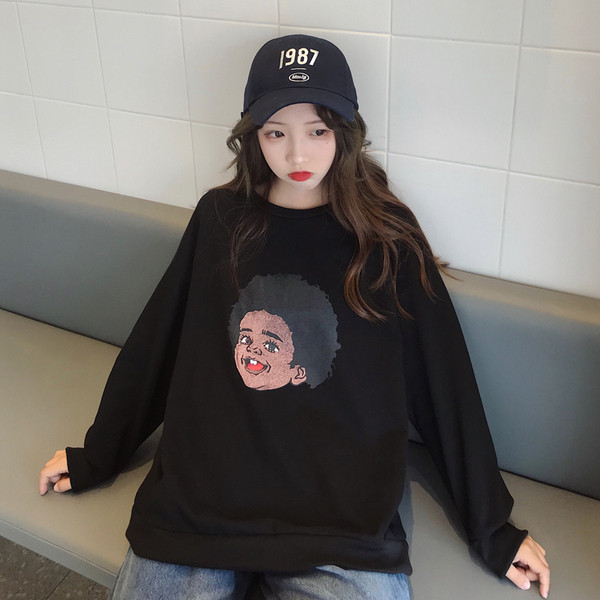 Μοντέρνα γυναικεία μπλούζα με εφαρμογές και στρογγυλη λαιμόκοψη σε μαύρο χρώμα