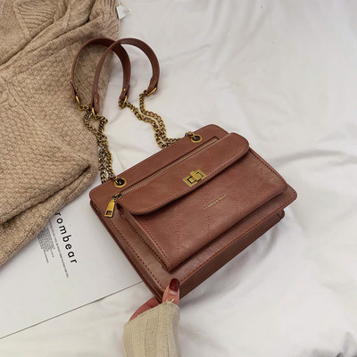 Γυναικεία τσάντα από συνθετικό δέρμα  με μεταλλική στερέωση σε διάφορα χρώματα