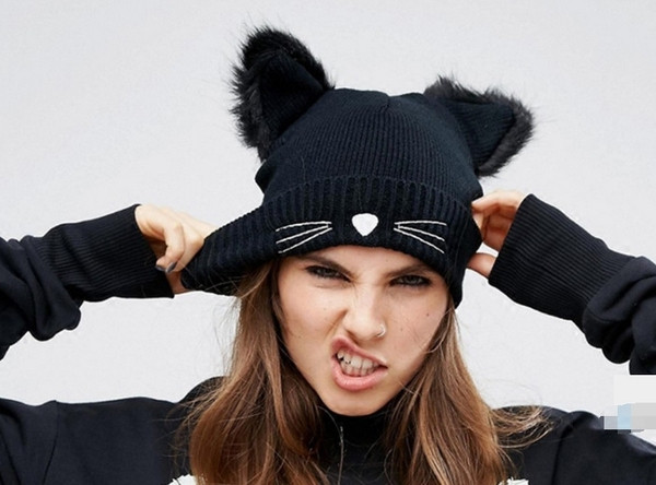 Modern női téli sapka tollal és rátéttel fekete színben