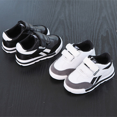 Modern children`s sneakers with stickers in white and black