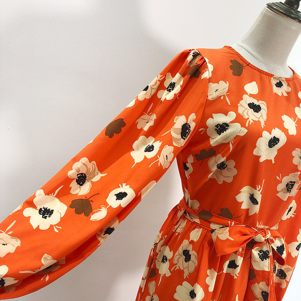 Hosszú ruha szabású modell narancssárga színben, virágmintával