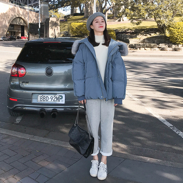 Modern női kabát kapucnival és fekete, fehér, kék és rózsaszín zsebekkel