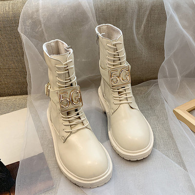 Cizmele moderne de piele de damă cu un element metalic sunt alb-negru