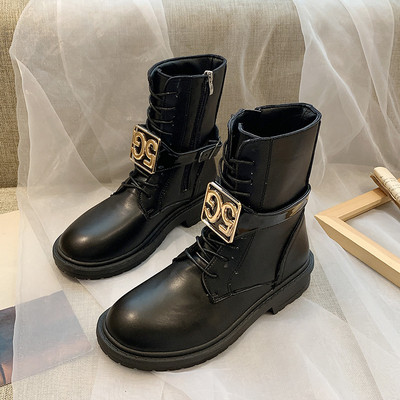 Cizmele moderne de piele de damă cu un element metalic sunt alb-negru