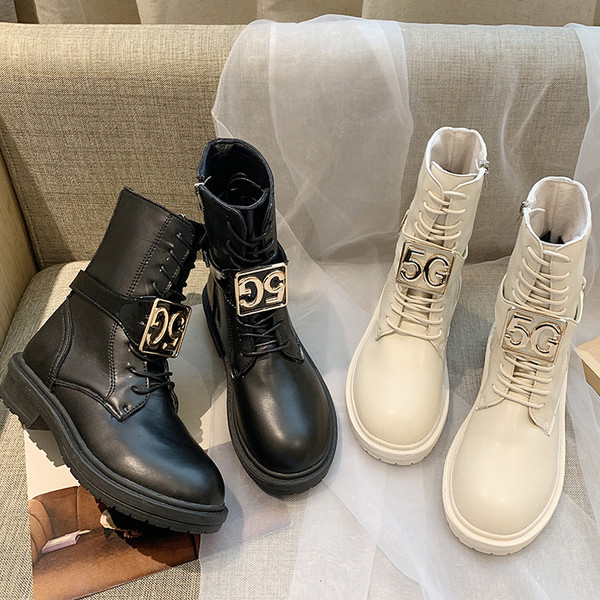 Cizmele moderne de piele de damă cu un element metalic sunt alb-negru