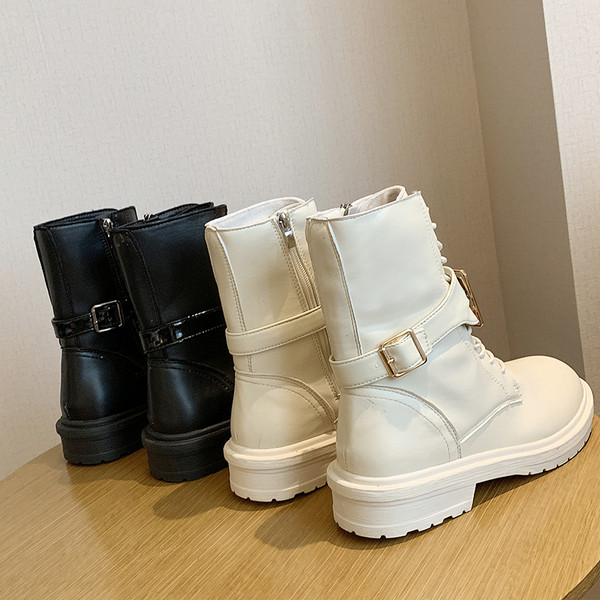 Cizmele moderne de piele de damă cu un element metalic sunt alb-negru