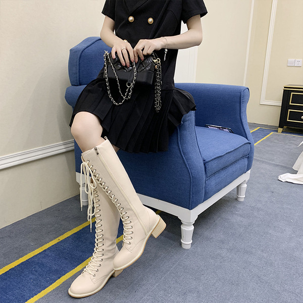 Női bőrcsizma fehér és fekete fűzővel