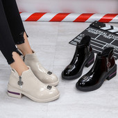 Cizmele moderne de damă cu un element metalic sunt alb-negru