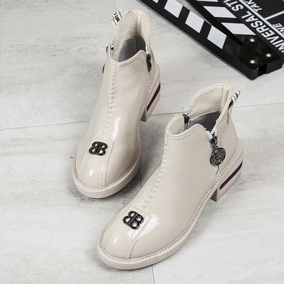 Cizmele moderne de damă cu un element metalic sunt alb-negru