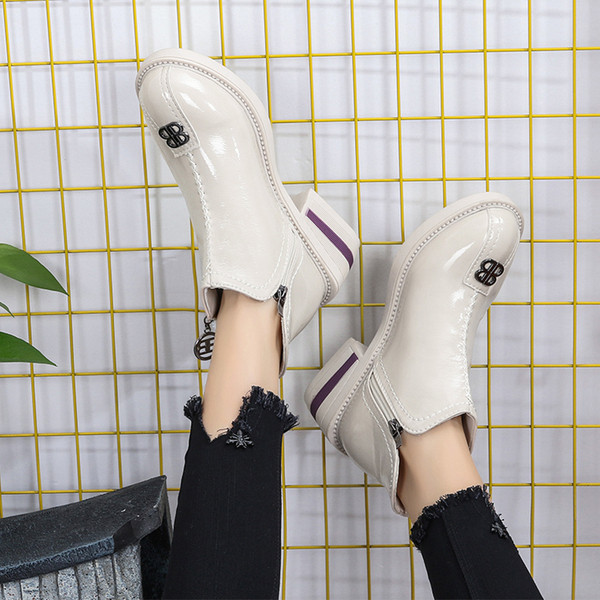 Cizmele moderne de damă cu un element metalic sunt alb-negru