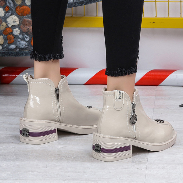 Cizmele moderne de damă cu un element metalic sunt alb-negru