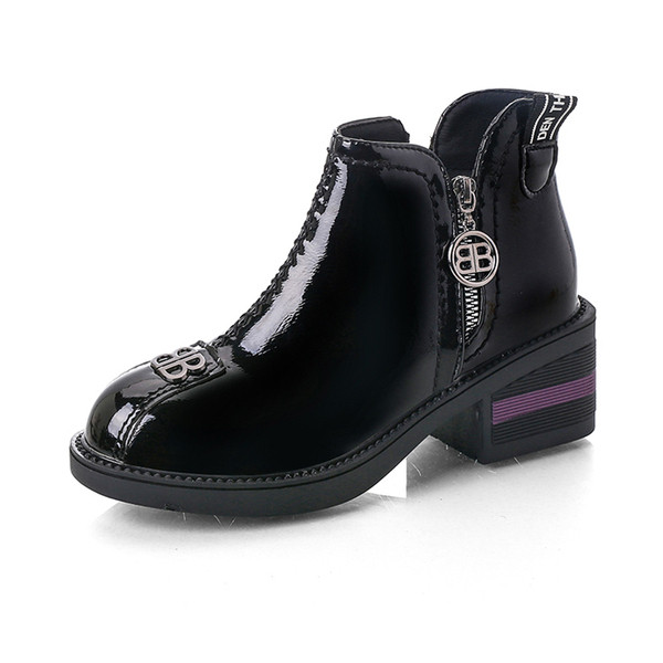 Cizmele moderne de damă cu un element metalic sunt alb-negru