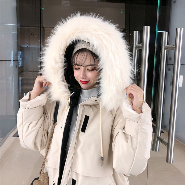 Hosszú téli kabát zsebekkel és kapucnival pehelyes