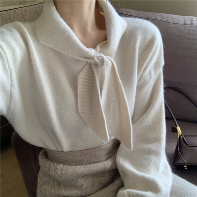 Vékony kötésből készült női blúz puffos ujjakkal és nyakkikötővel