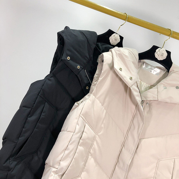 Hosszú téli mellény kapucnival fehér és fekete gombokkal