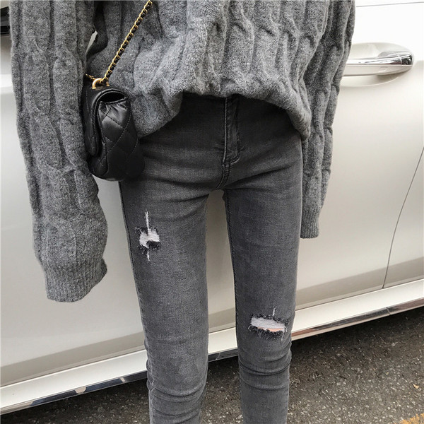 Szürke, testhezálló női farmer, szakadt motívumokkal