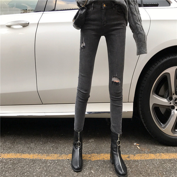 Szürke, testhezálló női farmer, szakadt motívumokkal