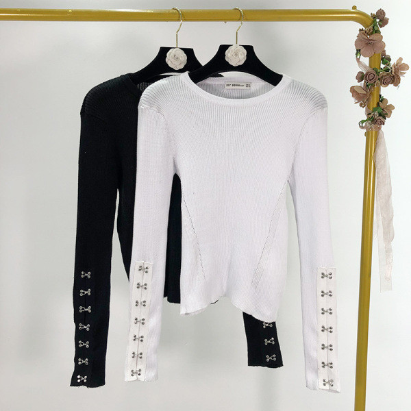 Női testhezálló blúz ovális nyakkivágással és fém elemekkel fehér és fekete színben